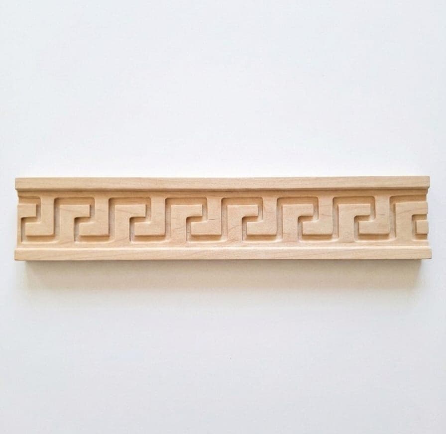 Cimaise Grecque en bois clair naturel sur fond blanc, motif de grecque continu sculpté en relief